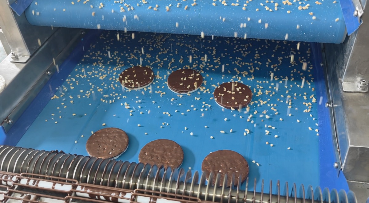 Factory test of chocolate-coated rice cakes during nut sprinkling