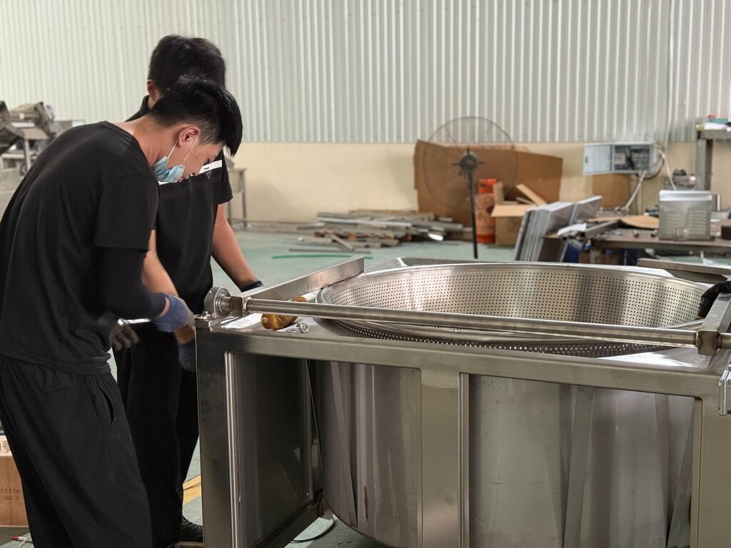 Workers assembling a stainless-steel food processing machine