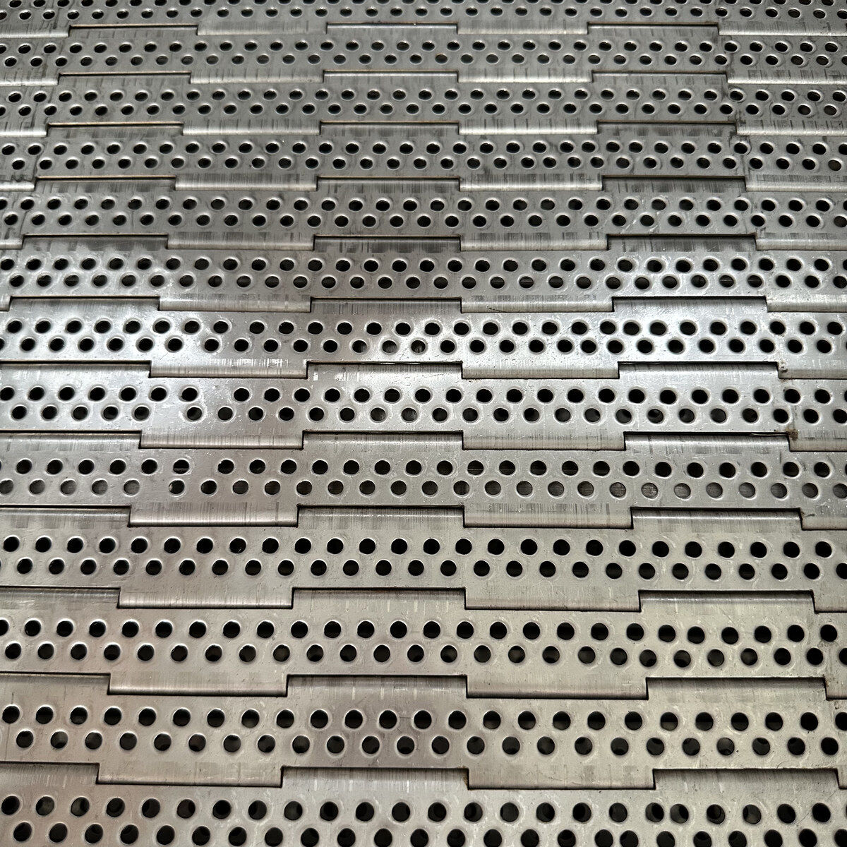 Conveyor plate surface close-up.