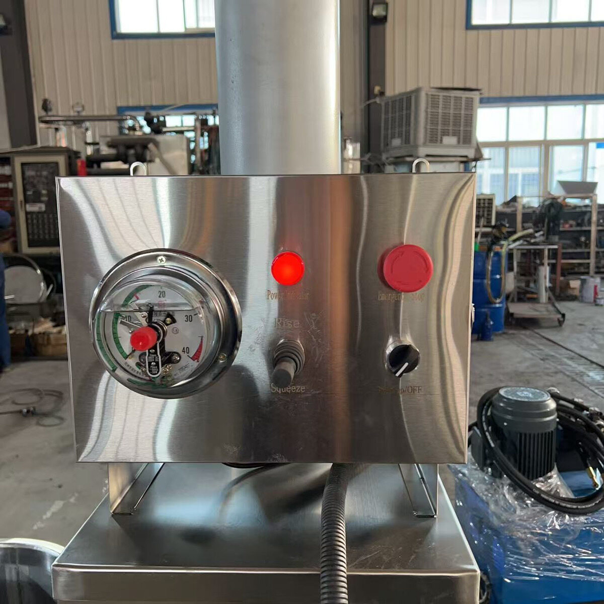 Buttons and gauge on the hydraulic press control panel.