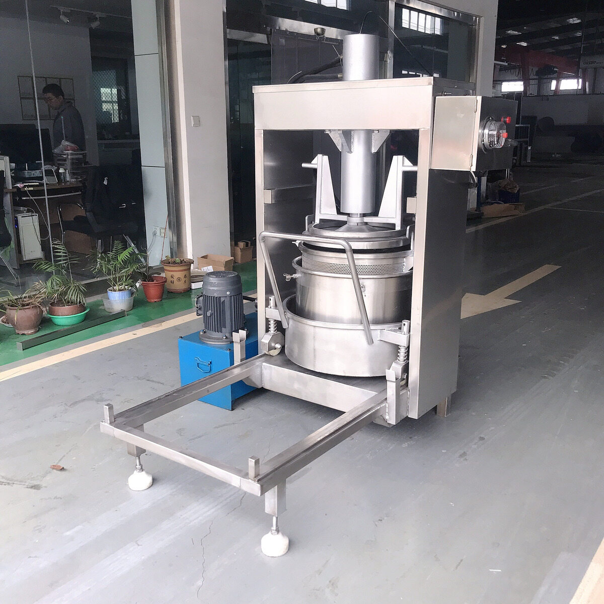 Hydraulic press with the basket beneath the pressing plate.