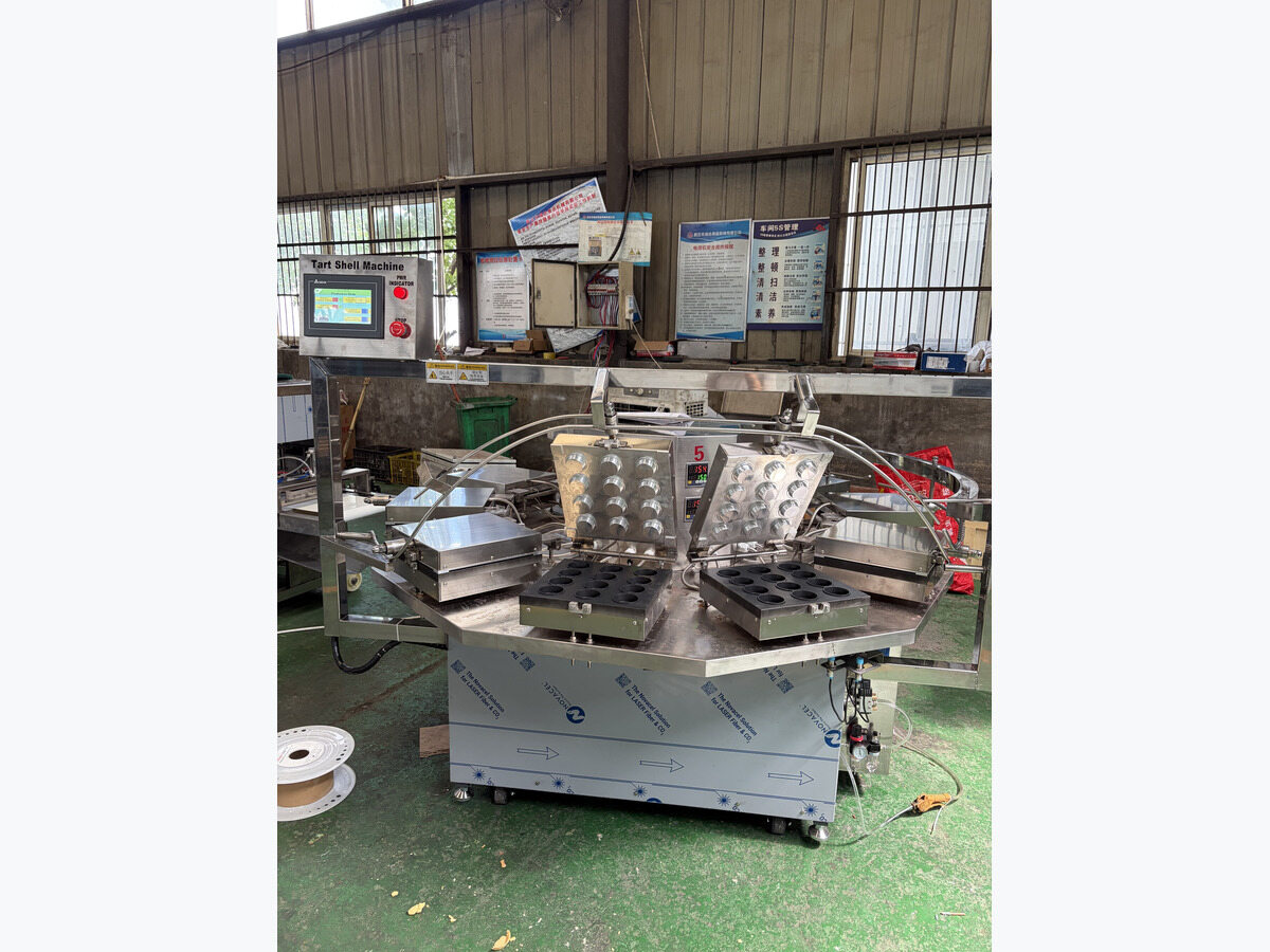 Rotary tart shell machine with open mould plates.